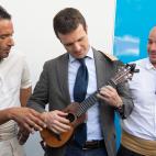 Entre mitin y mitin, toca una guitarrilla con aire brioso.